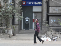 People pass next to HDFC Bank's ATM counter in Kolkata, India, on December 8, 2024. (