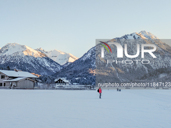 In Oberstdorf, Bavaria, Germany, on January 20, 2024, skiers glide across a flat, snow-covered trail surrounded by alpine scenery. The snow-...