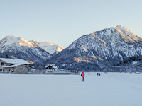 In Oberstdorf, Bavaria, Germany, on January 20, 2024, skiers glide across a flat, snow-covered trail surrounded by alpine scenery. The snow-...