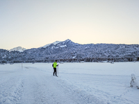 In Oberstdorf, Bavaria, Germany, on January 20, 2024, skiers glide across a flat, snow-covered trail surrounded by alpine scenery. The snow-...