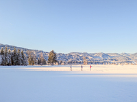 In Oberstdorf, Bavaria, Germany, on January 20, 2024, skiers glide across a flat, snow-covered trail surrounded by alpine scenery. The snow-...