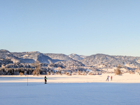 In Oberstdorf, Bavaria, Germany, on January 20, 2024, skiers glide across a flat, snow-covered trail surrounded by alpine scenery. The snow-...