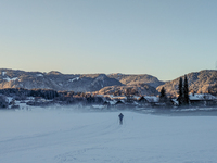 In Oberstdorf, Bavaria, Germany, on January 20, 2024, skiers glide across a flat, snow-covered trail surrounded by alpine scenery. The snow-...