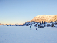 In Oberstdorf, Bavaria, Germany, on January 20, 2024, skiers glide across a flat, snow-covered trail surrounded by alpine scenery. The snow-...