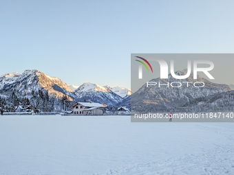 In Oberstdorf, Bavaria, Germany, on January 20, 2024, skiers glide across a flat, snow-covered trail surrounded by alpine scenery. The snow-...