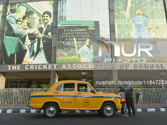 Shambhu Prasad, a yellow taxi driver, takes a selfie with his son along his yellow taxi in front of Eaden Gardens in Kolkata, India, on Dece...