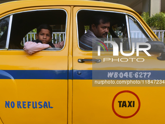 Shambhu Prasad, a yellow taxi driver, travels with his son in his yellow taxi in Kolkata, India, on December 8, 2024. Kolkata says goodbye t...