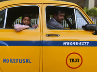 Shambhu Prasad, a yellow taxi driver, travels with his son in his yellow taxi in Kolkata, India, on December 8, 2024. Kolkata says goodbye t...