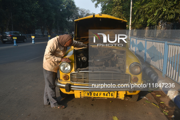 Akshil Yadav, a yellow taxi driver, checks his yellow taxi in Kolkata, India, on December 8, 2024. Kolkata says goodbye to its yellow taxis....