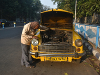 Akshil Yadav, a yellow taxi driver, checks his yellow taxi in Kolkata, India, on December 8, 2024. Kolkata says goodbye to its yellow taxis....