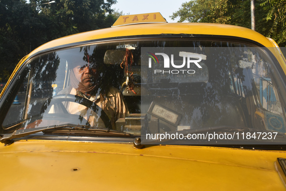 Akshil Yadav drives his yellow taxi in Kolkata, India, on December 8, 2024. Kolkata says goodbye to its yellow taxis. A court order removes...