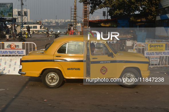 A yellow taxi driver sits inside his taxi and reads his newspaper in Kolkata, India, on December 8, 2024. Kolkata says goodbye to its yellow...