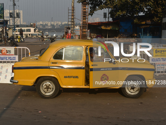 A yellow taxi driver sits inside his taxi and reads his newspaper in Kolkata, India, on December 8, 2024. Kolkata says goodbye to its yellow...