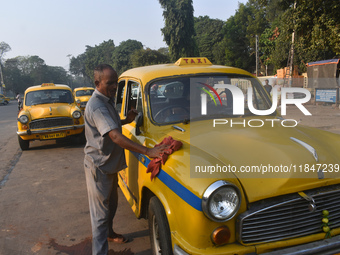 Babulal Prasad, a yellow taxi driver, cleans his taxi in Kolkata, India, on December 8, 2024. Kolkata says goodbye to its yellow taxis. A co...