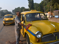 Babulal Prasad, a yellow taxi driver, cleans his taxi in Kolkata, India, on December 8, 2024. Kolkata says goodbye to its yellow taxis. A co...