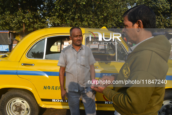 Babulal Prasad, a yellow taxi driver, talks with another taxi driver in Kolkata, India, on December 8, 2024. Kolkata says goodbye to its yel...