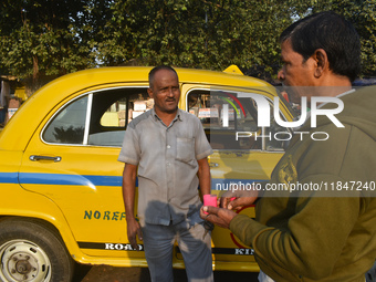 Babulal Prasad, a yellow taxi driver, talks with another taxi driver in Kolkata, India, on December 8, 2024. Kolkata says goodbye to its yel...