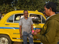 Babulal Prasad, a yellow taxi driver, talks with another taxi driver in Kolkata, India, on December 8, 2024. Kolkata says goodbye to its yel...