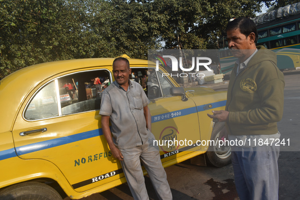 Babulal Prasad, a yellow taxi driver, talks with another taxi driver in Kolkata, India, on December 8, 2024. Kolkata says goodbye to its yel...