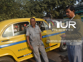 Babulal Prasad, a yellow taxi driver, talks with another taxi driver in Kolkata, India, on December 8, 2024. Kolkata says goodbye to its yel...