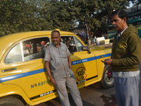 Babulal Prasad, a yellow taxi driver, talks with another taxi driver in Kolkata, India, on December 8, 2024. Kolkata says goodbye to its yel...