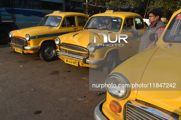 Yellow taxi drivers stand at a taxi stand in Kolkata, India, on December 8, 2024. Kolkata says goodbye to its yellow taxis. A court order re...