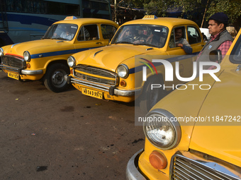 Yellow taxi drivers stand at a taxi stand in Kolkata, India, on December 8, 2024. Kolkata says goodbye to its yellow taxis. A court order re...