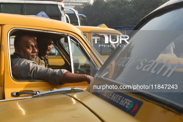 Yellow taxi drivers stand at a taxi stand in Kolkata, India, on December 8, 2024. Kolkata says goodbye to its yellow taxis. A court order re...