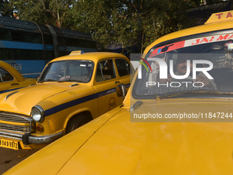 A yellow taxi driver sits inside his taxi and waits for passengers at a taxi stand in Kolkata, India, on December 8, 2024. Kolkata says good...