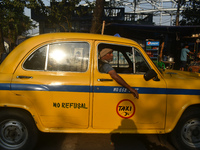 A yellow taxi driver sits inside his taxi and waits for passengers at a taxi stand in Kolkata, India, on December 8, 2024. Kolkata says good...