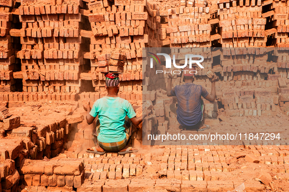 In Narsingdi, Dhaka, Bangladesh, on December 8, 2024, laborers carry piles of bricks weighing more than 15 kg on their heads in a brick kiln...