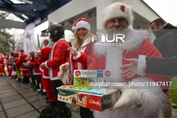 KRAKOW, POLAND - DECEMBER 08: Hundreds of motorcycle riders dressed as Santa Claus form a human chain to deliver Christmas gifts to young pa...