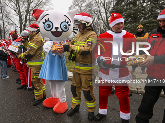 KRAKOW, POLAND - DECEMBER 08: Hundreds of motorcycle riders dressed as Santa Claus form a human chain to deliver Christmas gifts to young pa...