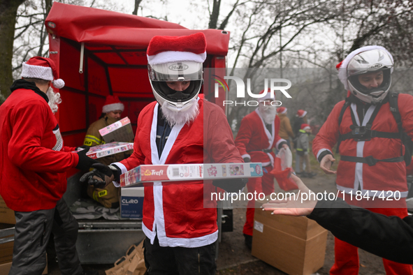 KRAKOW, POLAND - DECEMBER 08: Hundreds of motorcycle riders dressed as Santa Claus form a human chain to deliver Christmas gifts to young pa...