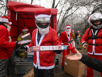 KRAKOW, POLAND - DECEMBER 08: Hundreds of motorcycle riders dressed as Santa Claus form a human chain to deliver Christmas gifts to young pa...