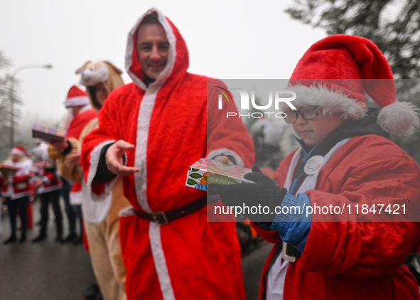 KRAKOW, POLAND - DECEMBER 08: Hundreds of motorcycle riders dressed as Santa Claus form a human chain to deliver Christmas gifts to young pa...