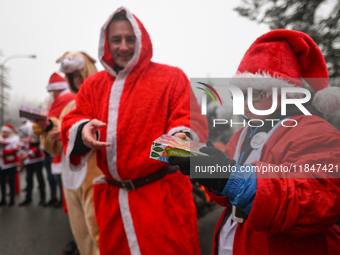 KRAKOW, POLAND - DECEMBER 08: Hundreds of motorcycle riders dressed as Santa Claus form a human chain to deliver Christmas gifts to young pa...