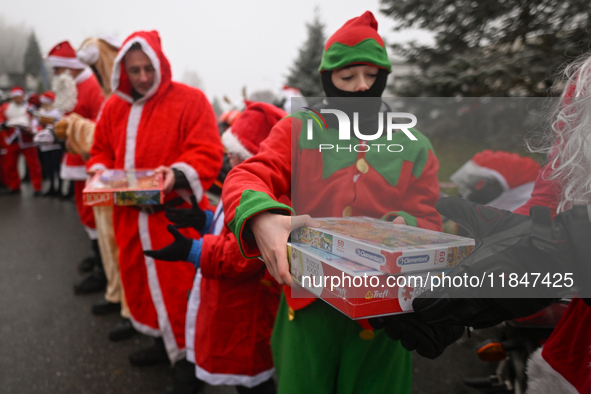 KRAKOW, POLAND - DECEMBER 08: Hundreds of motorcycle riders dressed as Santa Claus form a human chain to deliver Christmas gifts to young pa...