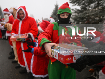 KRAKOW, POLAND - DECEMBER 08: Hundreds of motorcycle riders dressed as Santa Claus form a human chain to deliver Christmas gifts to young pa...