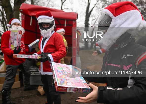 KRAKOW, POLAND - DECEMBER 08: Hundreds of motorcycle riders dressed as Santa Claus form a human chain to deliver Christmas gifts to young pa...