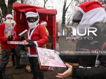 KRAKOW, POLAND - DECEMBER 08: Hundreds of motorcycle riders dressed as Santa Claus form a human chain to deliver Christmas gifts to young pa...