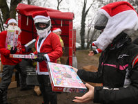 KRAKOW, POLAND - DECEMBER 08: Hundreds of motorcycle riders dressed as Santa Claus form a human chain to deliver Christmas gifts to young pa...