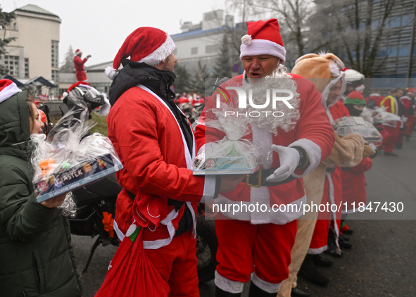 KRAKOW, POLAND - DECEMBER 08: Hundreds of motorcycle riders dressed as Santa Claus form a human chain to deliver Christmas gifts to young pa...