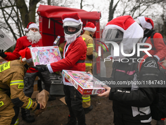 KRAKOW, POLAND - DECEMBER 08: Hundreds of motorcycle riders dressed as Santa Claus form a human chain to deliver Christmas gifts to young pa...