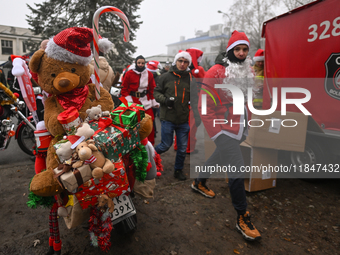 KRAKOW, POLAND - DECEMBER 08: Hundreds of motorcycle riders dressed as Santa Claus form a human chain to deliver Christmas gifts to young pa...