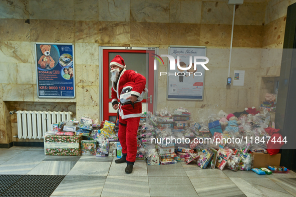 KRAKOW, POLAND - DECEMBER 08: A Santa poses for a photo with Christmas Gifts at the entrance to the Pediatric Hospital in Krakow, as hundred...