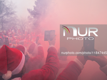 KRAKOW, POLAND - DECEMBER 08: Motorcycle riders dressed as Santa Claus take pictures with their mobile phones during a burnout demonstration...