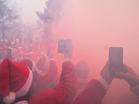 KRAKOW, POLAND - DECEMBER 08: Motorcycle riders dressed as Santa Claus take pictures with their mobile phones during a burnout demonstration...