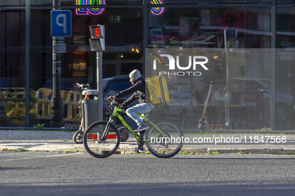 A food delivery person rides a bike in Lisbon, Portugal, on December 8, 2024. Glovo, the app-based food delivery service, hires its freelanc...