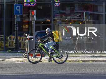 A food delivery person rides a bike in Lisbon, Portugal, on December 8, 2024. Glovo, the app-based food delivery service, hires its freelanc...